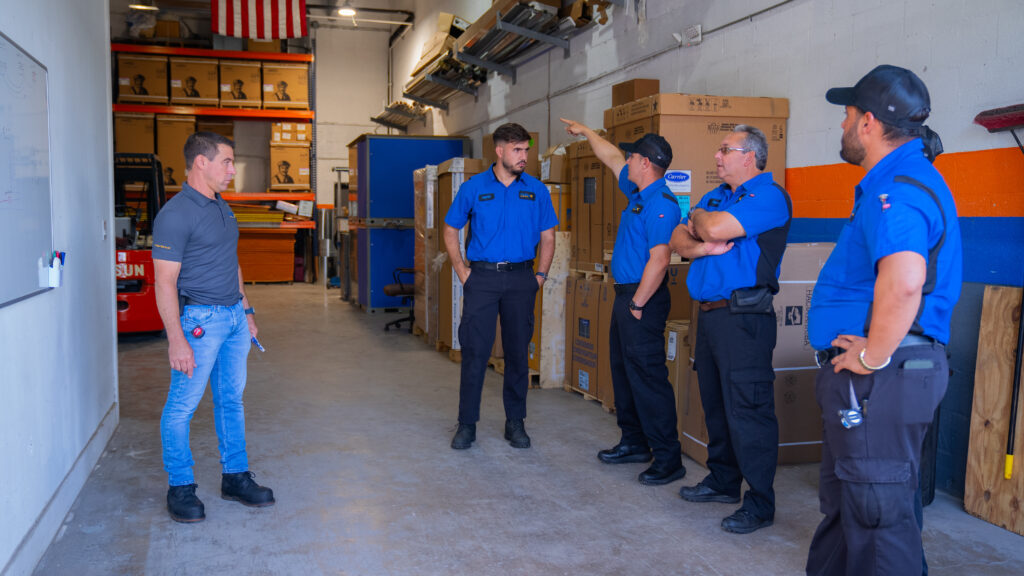 pollux air hvac specialists in warehouse discussing inventory